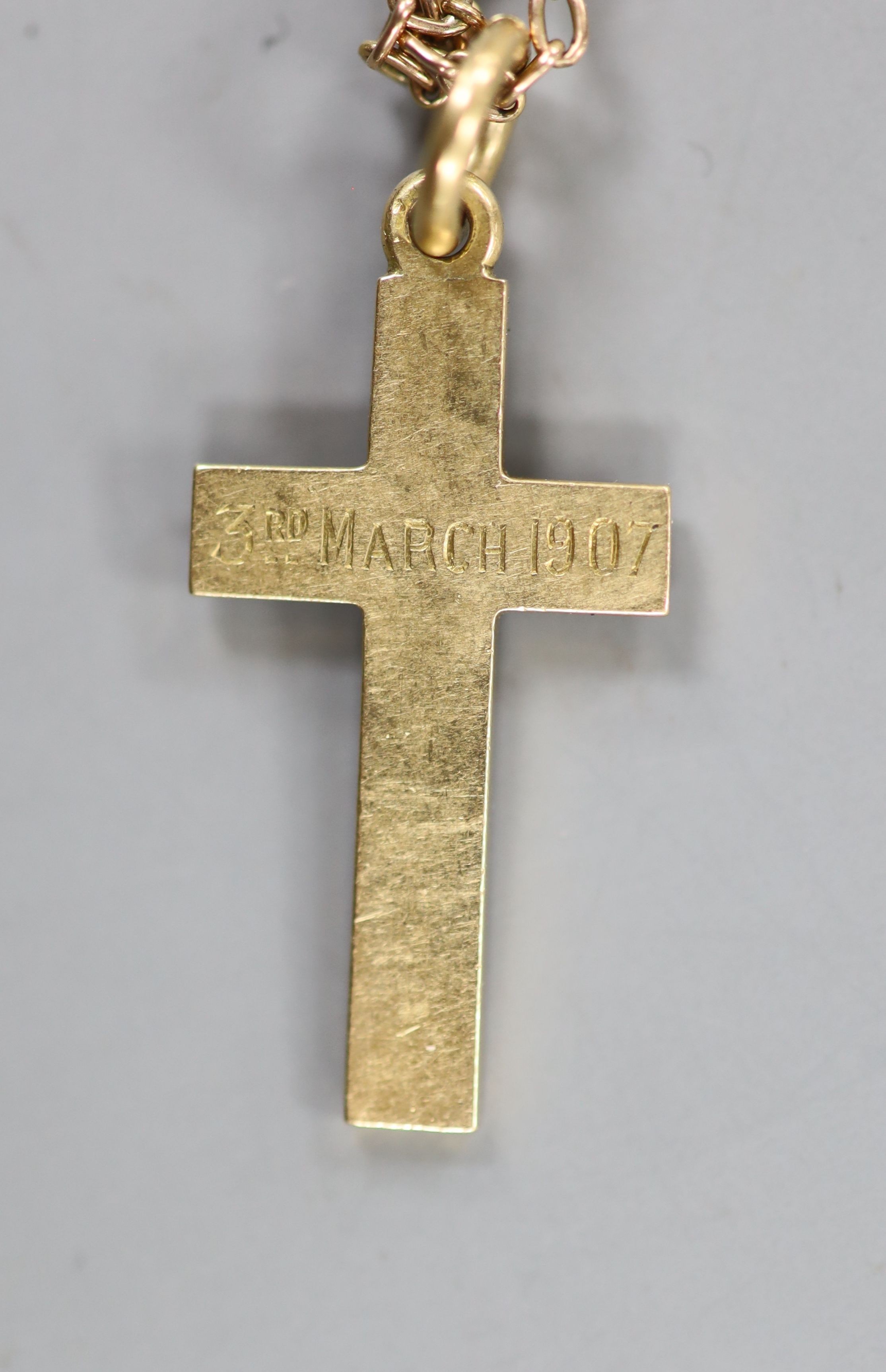 An Edwardian yellow meta cross pendant with engraved inscription, 29mm, on a yellow metal (stamped 9) and seed pearl chain, 72cm, gross weight 88 grams.